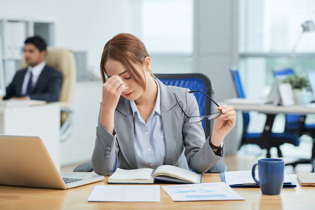 medium-shot-young-asian-woman-sitting-desk-office-rubbing-nose_1098-17106.jpg